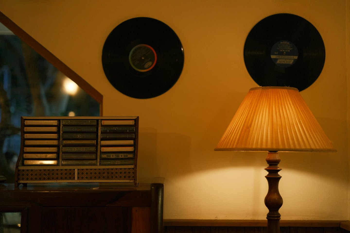 Ein Vintage-Kassettenhalter steht auf einem Schreibtisch neben Schallplatten.